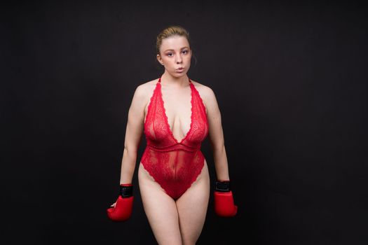 Boxer, seductive confident female boxer with gloves studio, sporty woman posing looking to camera.