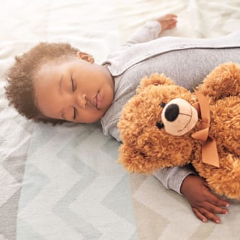 His snuggly, cuddly, nap buddy. a little baby boy sleeping on a bed with a teddy bear
