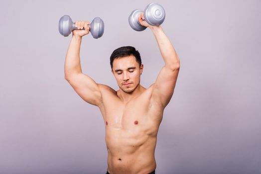 Portrait young fitness sporty strong man barechested muscular sportsman isolated on grey dark.