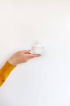 A female hand holds a delicious cupcake, congratulations on a happy birthday. Place for an inscription