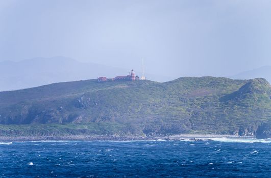 Lighthouse and keepers house on the cliffs of Hornos Island near Cape Horn in Chile
