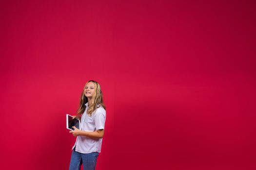 Online school app. Schoolgirl showing tablet computer Empty Screen On red Background. Studio Shot