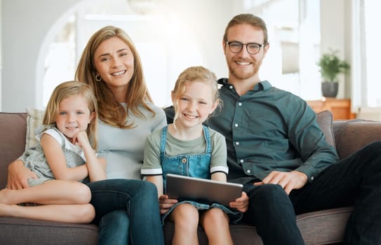 We take family time very seriously. a young family sitting on the sofa together and bonding while using technology