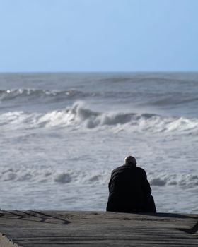 The Beauty of Solitude by the Sea. Old person alone contemplating the infinite blue.