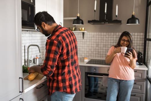 Millennial couple in quarrel and woman with smartphone ignoring each other having breakfast together at home, gadget overuse - communication problem family