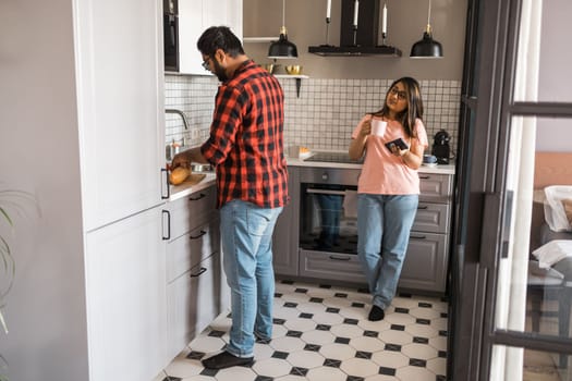 Millennial couple in quarrel and woman with smartphone ignoring each other having breakfast together at home, gadget overuse - communication problem family