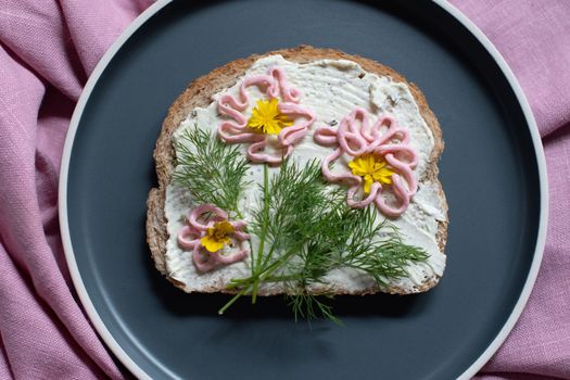 creative sandwich with soft cheese and pink pasta tarama greens, flowers are drawn on the sandwich. High quality photo