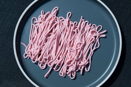 pink tarama pasta on a gray plate squeezed out of a cooking bag, creative texture. High quality photo