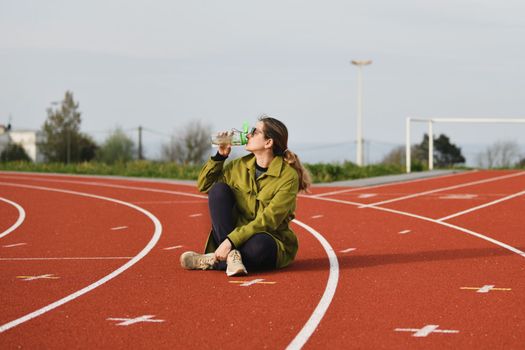 Woman drinking water at the stadium