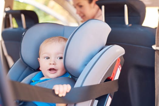 Lets go, Mom. a mother sitting in a car with her baby boy in a car seat