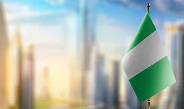 Small flags of the Nigeria on an abstract blurry background.