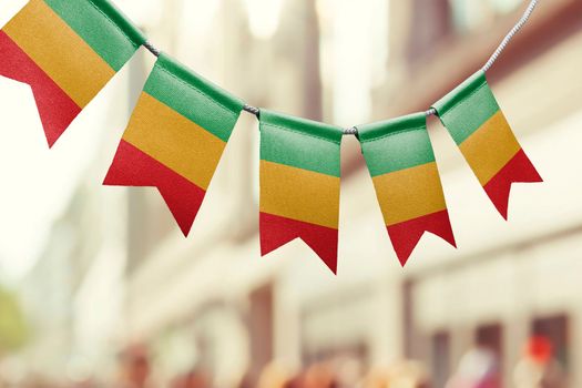 A garland of Mali national flags on an abstract blurred background.