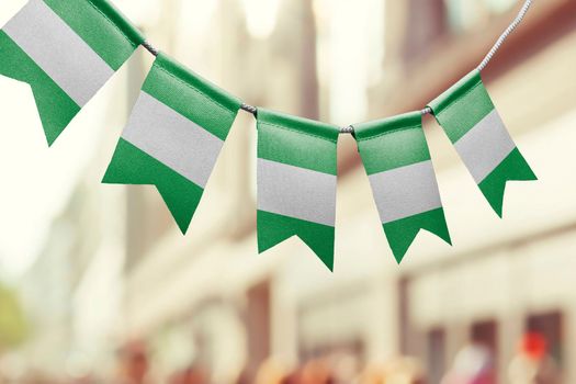 A garland of Nigeria national flags on an abstract blurred background.