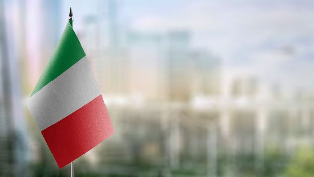 Small flags of the Italy on an abstract blurry background.