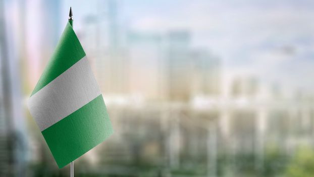 Small flags of the Nigeria on an abstract blurry background.