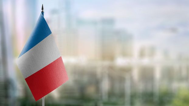 Small flags of the France on an abstract blurry background.