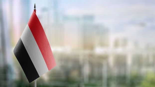 Small flags of the Yemen on an abstract blurry background.