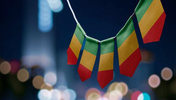 A garland of Mali national flags on an abstract blurred background.