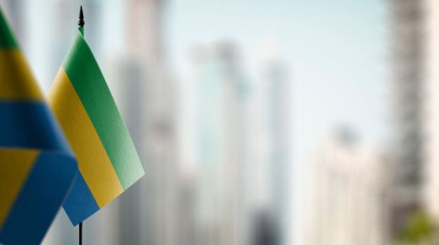 Small flags of the Gabon on an abstract blurry background.
