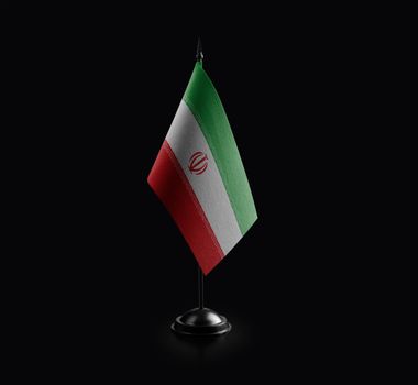 Small national flag of the Iran on a black background.
