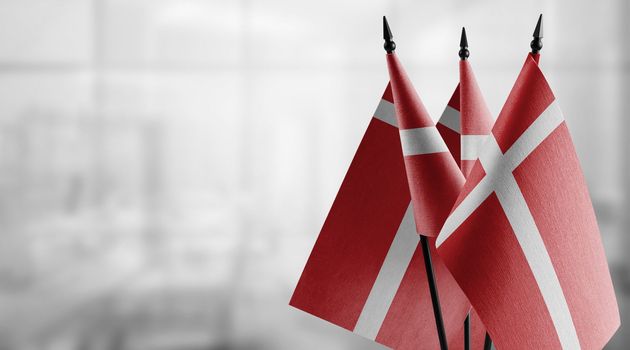 A small Denmark flag on an abstract blurry background.