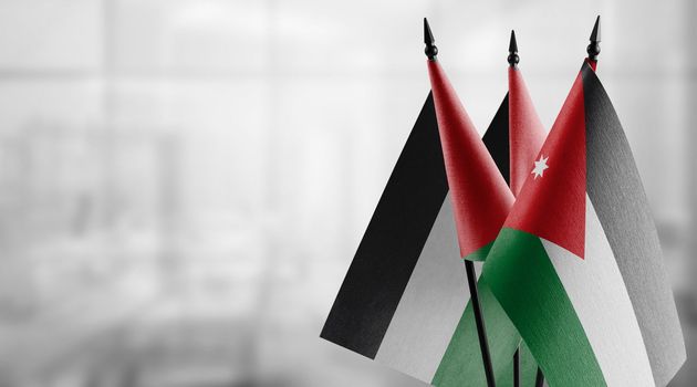 Small flags of the Jordan on an abstract blurry background.