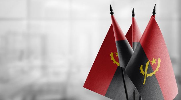 A small Angola flag on an abstract blurry background.