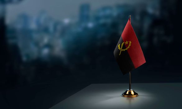 A small Angola flag on an abstract blurry background.