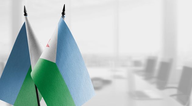 Small flags of the Djibouti on an abstract blurry background.