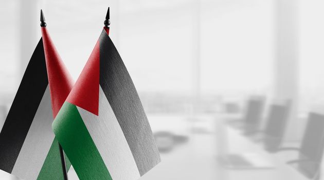 Small flags of the Jordan on an abstract blurry background.