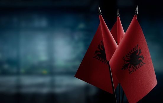 A small Albania flag on an abstract blurry background.