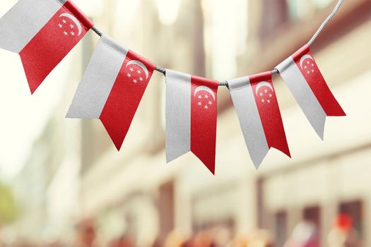 A garland of Singapore national flags on an abstract blurred background.