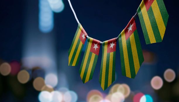 A garland of Togo national flags on an abstract blurred background.