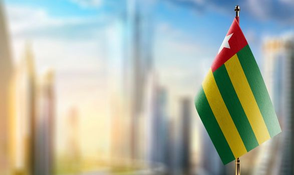 Small flags of the Togo on an abstract blurry background.