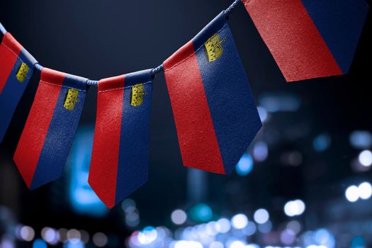 A garland of Liechtenstein national flags on an abstract blurred background.