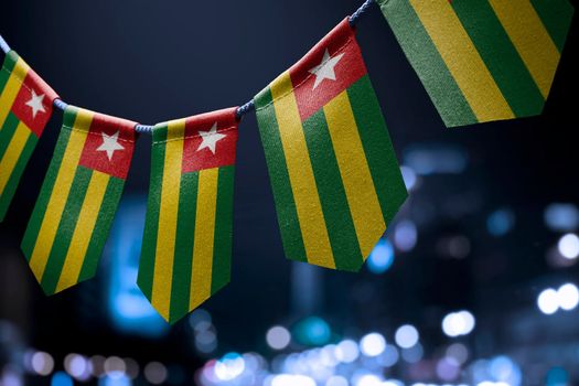 A garland of Togo national flags on an abstract blurred background.