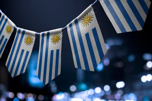 A garland of Uruguay national flags on an abstract blurred background.