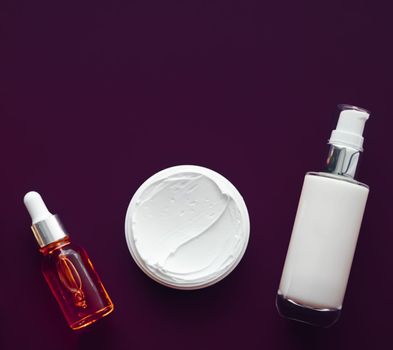 Beauty cosmetics and skincare product on purple background, flatlay.