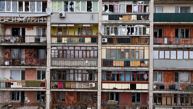 An apartment building in a war zone. Damage to a house as a result of artillery shelling. War in residential areas, broken windows and burned apartments. Armed conflict in Ukraine.