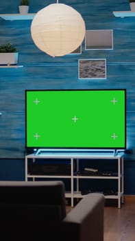 Nobody in living room with green screen display in modern decorated flat. Television with chroma key with isolated background using copy space and mockup template