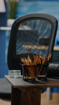 Empty artwork studio room with colorful pencils and vase for drawing occupation. Nobody in creativity space but art tools, wooden easel, craft equipment for artistic design and masterpiece