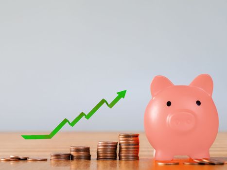 Saving money concept. piggy bank, stack of silver coins with growth money and green arrow up, Save money for preparing in future, Finance. growing Investmenst savings business concept copy space