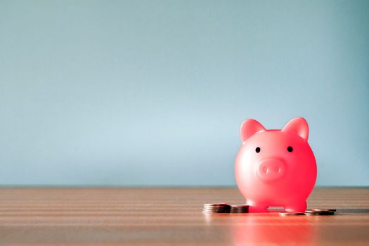 Piggy Bank and a few coins on gray background. The concept of saving less saving money piggy bank and financial planning concept, broke and poor copy space close up