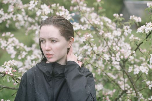 beautiful young woman near the blossoming spring tree. Emotional woman portrait