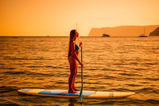 Close up shot of happy young caucasian woman looking at camera and smiling. Cute woman portrait in bikini posing on a volcanic rock high above the sea