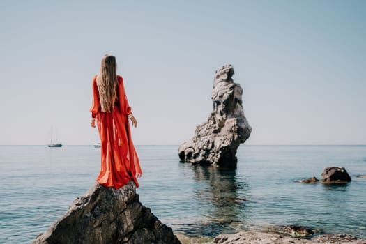 Woman travel sea. Happy tourist taking picture outdoors for memories. Woman traveler looks at the edge of the cliff on the sea bay of mountains, sharing travel adventure journey.