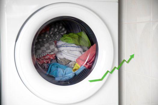 Concept of saving electricity with a washing machine white electrical power strip and green arrow up. Financial home savings concept environment