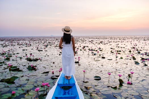 Asian women in a boat at the Beautiful Red Lotus Sea in Udon Thani in northern Thailand. Flora of Southeast Asia.