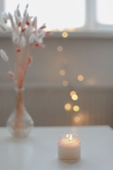 Cozy home composition with candle on a blurred background.