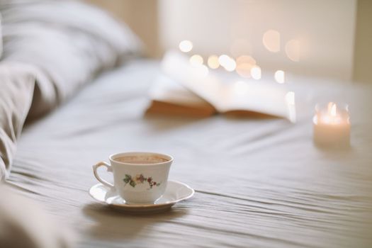 Spring still life. Breakfast in bed. White bedroom. Sweet home. Book and coffee cup